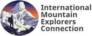 Logo of the International Mountain Explorers Connection with an illustration of a person standing on a rocky terrain, gazing at a snow-capped mountain during sunset.