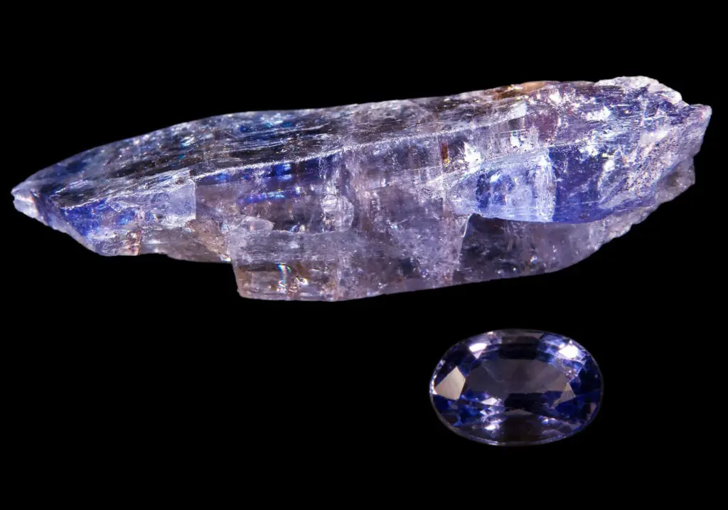 A rough tanzanite crystal and a faceted tanzanite gemstone set against a black background, capturing the allure of Tanzania—visit this stunning land to experience its rare treasures firsthand.