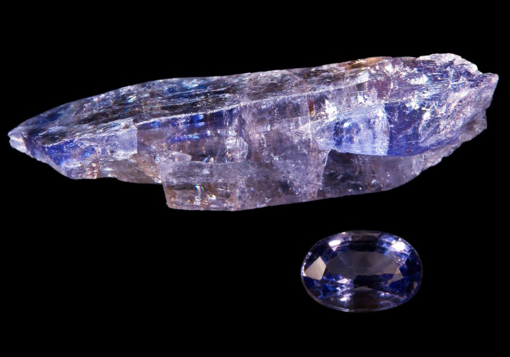A rough tanzanite crystal and a faceted tanzanite gemstone set against a black background, capturing the allure of Tanzania—visit this stunning land to experience its rare treasures firsthand.